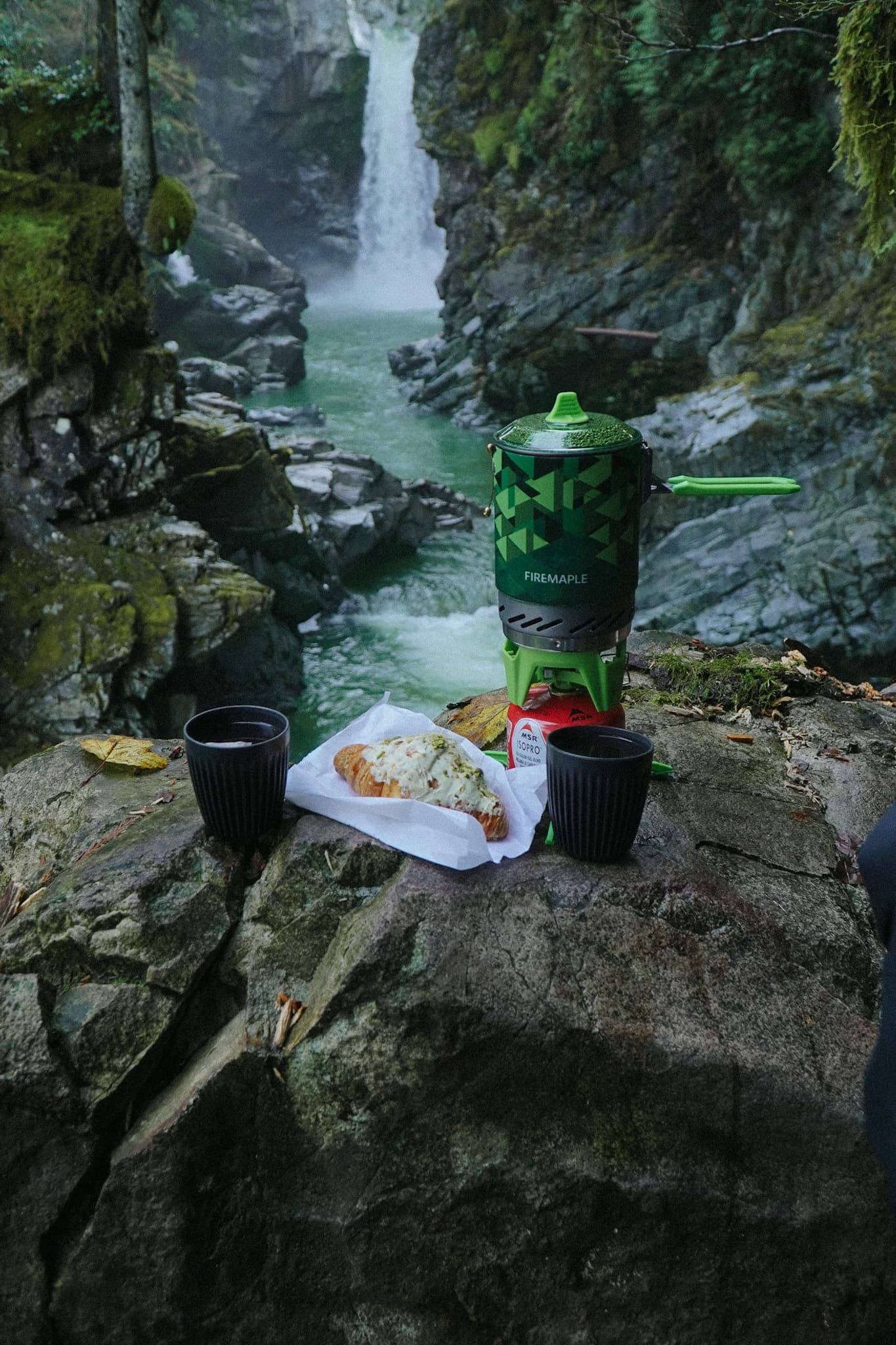 Product in nature — camp stove by waterfall